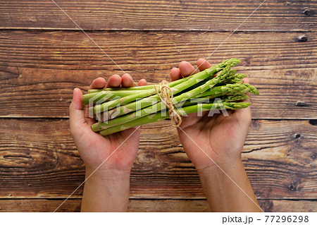 Fresh green asparagus in hand Fresh green asparagus in hand 77296298