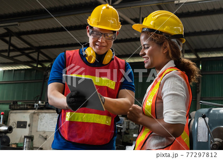 Two skillful factory engineer or worker discussing project on tablet computer 77297812