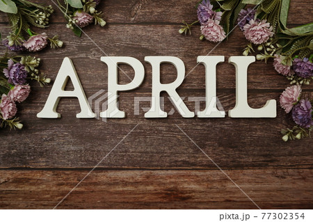 April alphabet letters with flower decoration on wooden background 77302354