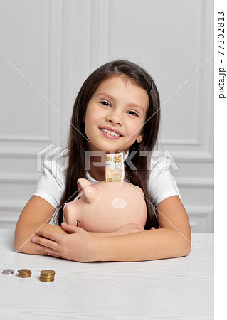 Little child girl with piggy bank at home Little child girl with piggy bank at home 77302813