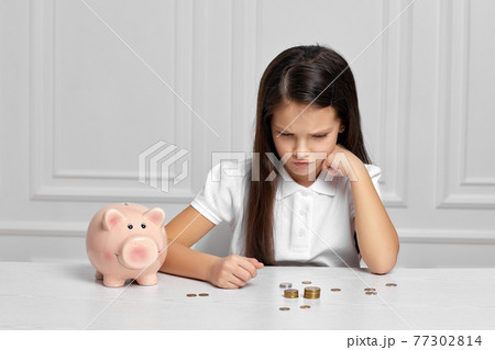 Little child girl with piggy bank at home Little child girl with piggy bank at home 77302814