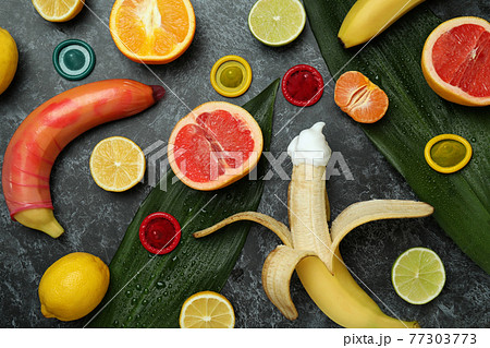 Sex concept with fruits and condoms on dark background Sex concept with fruits and condoms on dark background 77303773