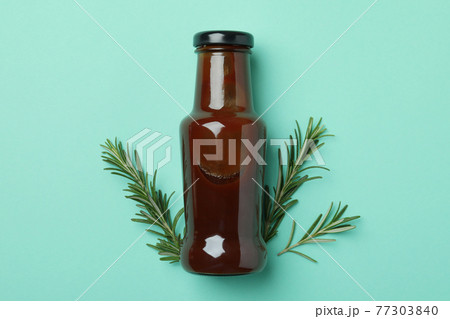Bottle of barbecue sauce and rosemary on mint background 77303840