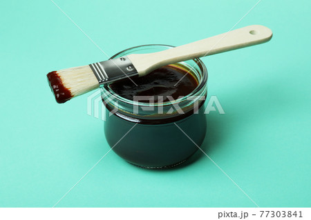 Glass jar of barbecue sauce and brush on mint background 77303841