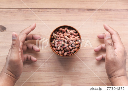 Processed pea nuts in a bowl on table top down . Processed pea nuts in a bowl on table top down . 77304872