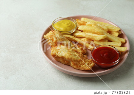 Plate with fried fish and chips, and sauces on white textured background 77305322