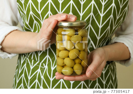 Woman hold jar of olives, close up Woman hold jar of olives, close up 77305417