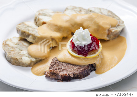 sirloin sauce with dumplings and cranberries on lemon with whipped cream 77305447