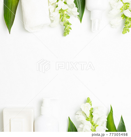 Spa bathroom products. Soap, shower towel, shampoo bottle with flowers on white background. top view, copy space 77305498