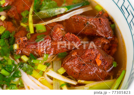 cooked beef with green onions, in cooked broth, served with greenery cooked beef with green onions, in cooked broth, served with greenery 77305823