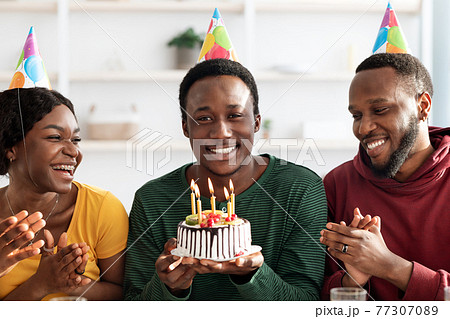 Happy black young friends celebrating birthday together at home 77307089