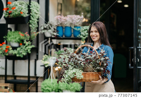 Working in flower store and taking care of plants outdoor Working in flower store and taking care of plants outdoor 77307145