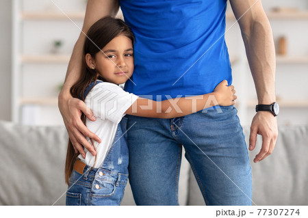 Portrait of father and daughter hugging at home 77307274