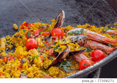 Close up: cooked paella with shrimp, musse, rice, cherry tomato - street food Close up: cooked paella with shrimp, musse, rice, cherry tomato - street food 77308271