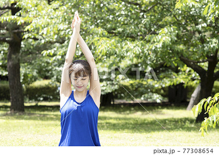 公園でヨガをする女性 77308654