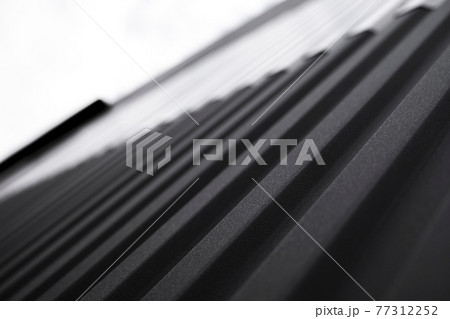 Black and white corrugated iron sheet used as a facade of a warehouse or factory. Texture of a seamless corrugated zinc sheet metal aluminum facade. Architecture. Metal texture. Black and white corrugated iron sheet used as a facade of a warehouse or factory. Texture of a seamless corrugated zinc sheet metal aluminum facade. Architecture. Metal texture. 77312252