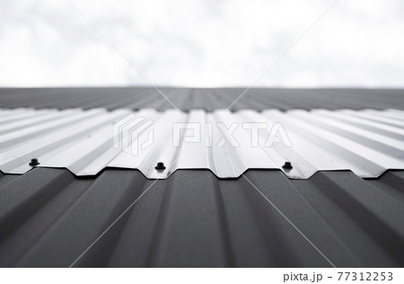 Black and white corrugated iron sheet used as a facade of a warehouse or factory. Texture of a seamless corrugated zinc sheet metal aluminum facade. Architecture. Metal texture. Black and white corrugated iron sheet used as a facade of a warehouse or factory. Texture of a seamless corrugated zinc sheet metal aluminum facade. Architecture. Metal texture. 77312253