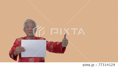 Asian seniior elder man in Chinese new year red costume holding white board space for holiday sale 77314129