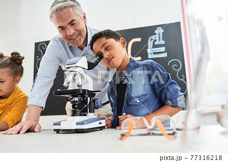 Handsome grey haired teacher looking satisfied to the boy 77316218