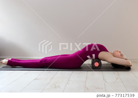 Beautiful woman pilates instructor stretching and warming up using foam roller, working out, wearing pink sportswear, close up. Sport and healthy active lifestyle concept. Beautiful woman pilates instructor stretching and warming up using foam roller, working out, wearing pink sportswear, close up. Sport and healthy active lifestyle concept. 77317539