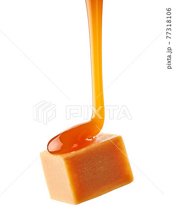 caramel sauce flowing on flying caramel candy 77318106