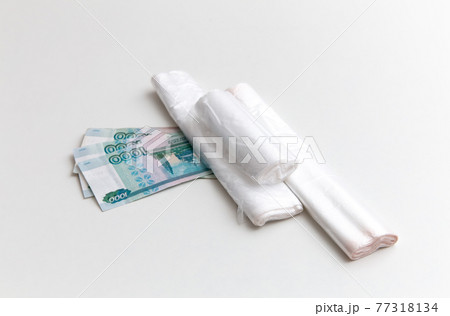 Plastic bags are on the ruble banknotes on the white background. Package, rolls Plastic bags are on the ruble banknotes on the white background. Package, rolls 77318134