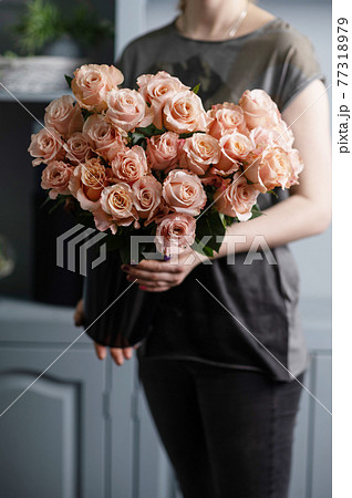 Bright pink spray roses in female hands  77318979