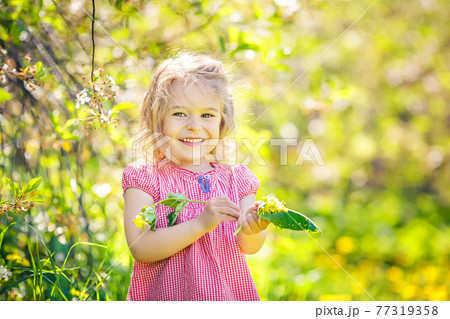 Happy little girl in spring sunny park Happy little girl in spring sunny park 77319358
