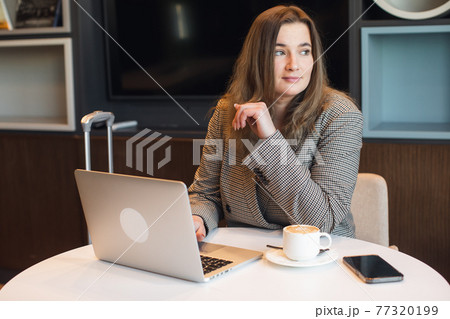 young business woman uses the phone. Attractive woman scrolling pages, tapping on touchscreen, checking news and financial charts 77320199