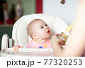 Close up of a mother feeding her baby 77320253