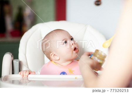 Close up of a mother feeding her baby 77320253
