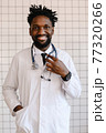 close-up portrait of black doctor smiling and looking at camera 77320266