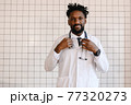 close-up portrait of black doctor smiling and looking at camera 77320273
