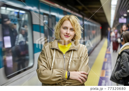 Subway station in Istanbul, Turkey, young Caucasian woman stands on platform while waiting for train. 77320680