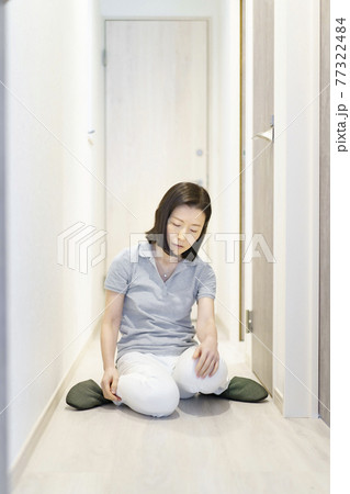 疲れて、廊下で座り込む中年女性 疲れて、廊下で座り込む中年女性 77322484