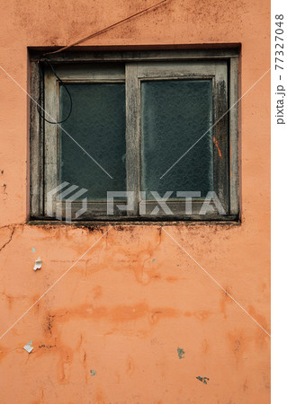 Old window with orange wall 77327048