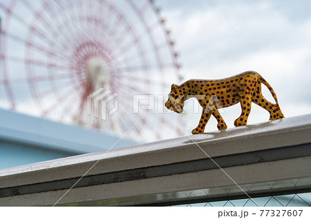 木彫りのチーターと、大きな観覧車 77327607