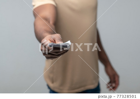 Male hand with banknotes outstretched forward 77328501