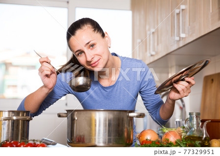Housewife cooking vegetable soup 77329951