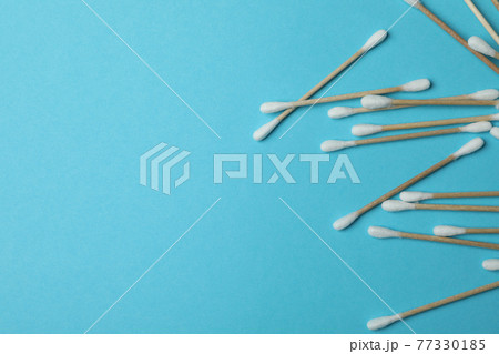 Cotton swabs on blue background, space for text 77330185