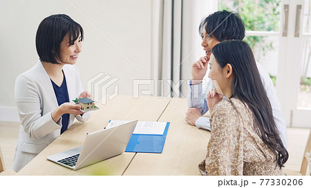 カップルと面談する女性　ハウスメーカー　設計士 77330206