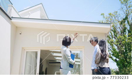 カップルに物件を案内する女性担当者 モデルハウス ハウスメーカー 部屋探し カップルに物件を案内する女性担当者 モデルハウス ハウスメーカー 部屋探し 77330233