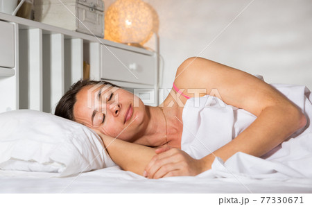 Adult female is sleeping on bed in bedroom at home 77330671