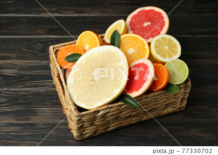 Basket with fresh citrus on wooden table 77330702