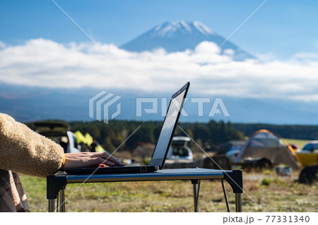富士山の麓でリモートワークをする女性の手 77331340