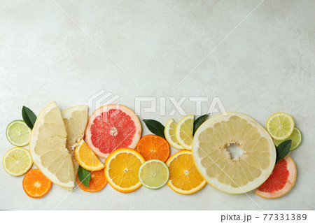 Ripe citrus slices on white textured background 77331389