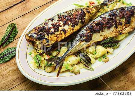 Baked scomber with potatoes,wooden table 77332203