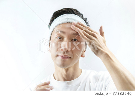 顔にクリームを塗る男性 77332546