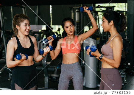 Cheerful diverse group of sportswomen exercising in gym Cheerful diverse group of sportswomen exercising in gym 77333159