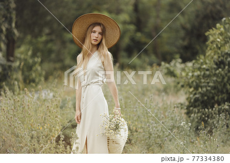 Woman with Flowers in Nature in the Summer. 77334380